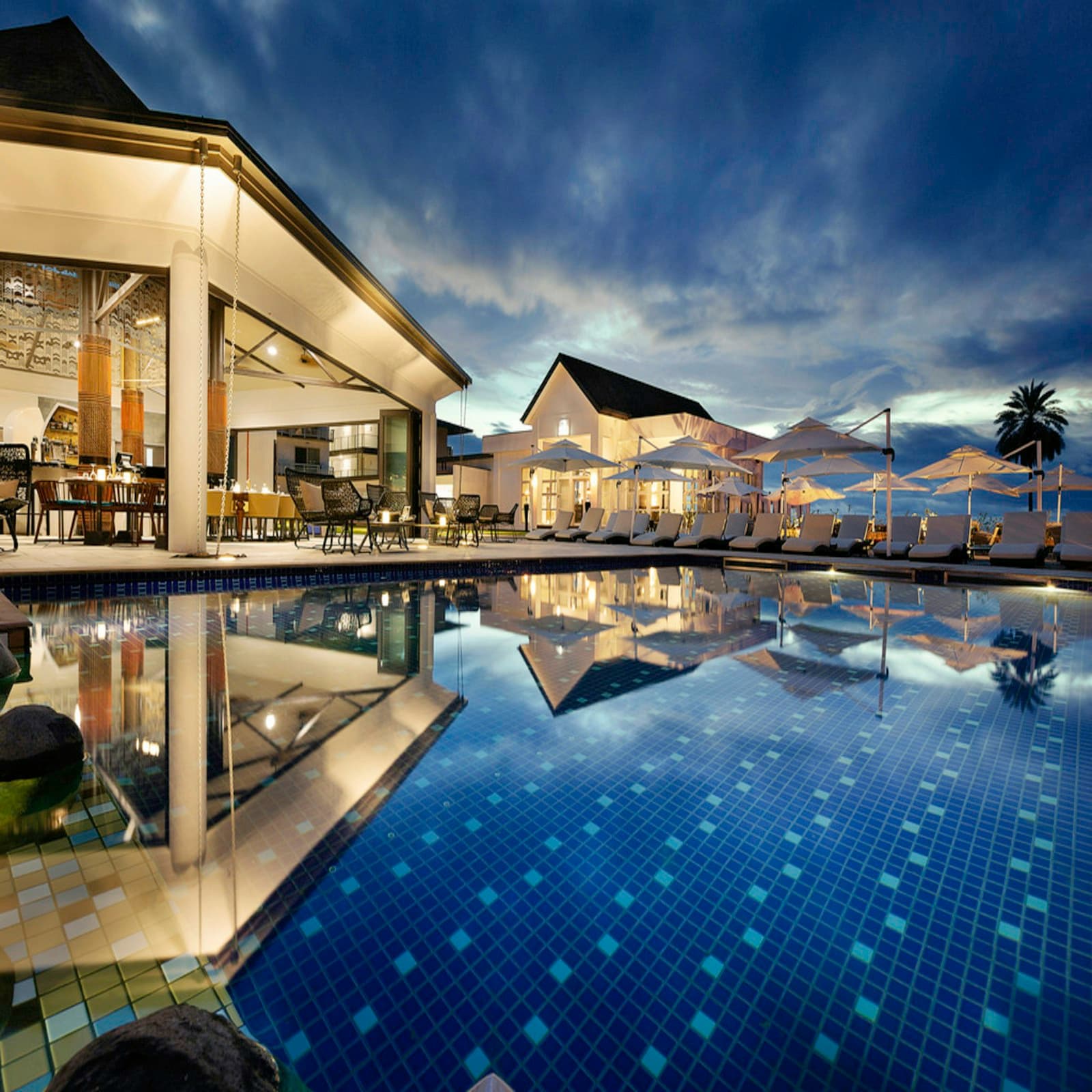 Luxury wedding resort in Varanasi with swimming pool, landscaped gardens, and illuminated evening reception setup
